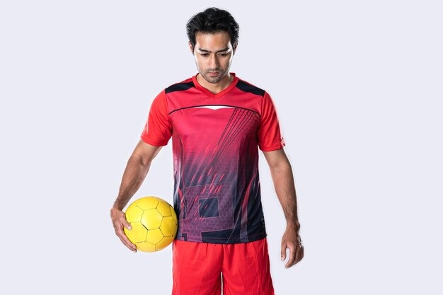 Unleash Your Team Spirit with Trendy Jerseys Online 2 Male soccer player in orange goalkeeper jersey posing confidently on gray wall
