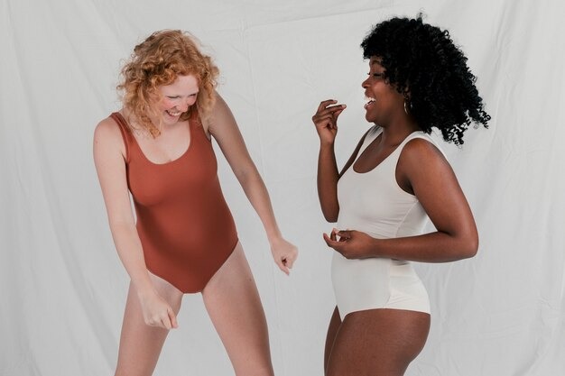 How to Choose Pieces That Flatter Your Natural Shape 3 Two young multi-ethnic women having fun and posing against a grey background